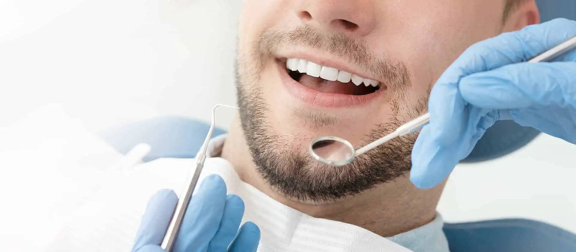 Lächelnder Mann bei der professionellen Zahnreinigung